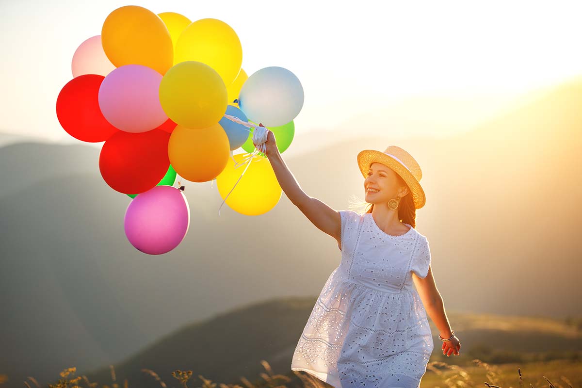 a woman running with balloons while learning benefits of tms therapy